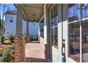 Inviting front porch with brick pillars, hanging pendant light and a brick-paved floor at 3255 Hilltop Cir, Marietta, GA 30066