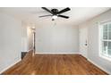 Open-concept living area with hardwood floors, white walls, and modern ceiling fan at 60 Collins Rd, Carrollton, GA 30116