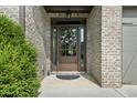 Inviting front door with brick surround, decorative wreath and an elegant light fixture at 1605 Camden Cove Dr, Cumming, GA 30040