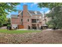 Backyard with a stone patio, fire pit, outdoor seating, and well-maintained lawn at 4992 Price Dr, Suwanee, GA 30024