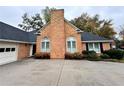 Close up of a well-maintained brick facade with a black roof, contrasted by neat landscaping at 2020 Wynfield Point Dr, Buford, GA 30519