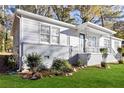 Cozy single-story home with charming front porch, updated brick foundation, and lush greenery at 1652 Pine Cir, Austell, GA 30168