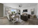 Comfortable living room showcasing modern decor, a ceiling fan, and large windows for natural light at 371 Foxglove Way, Mcdonough, GA 30253