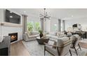 Stylish living room featuring a fireplace, hardwood floors, and comfortable seating arrangement at 371 Foxglove Way, Mcdonough, GA 30253