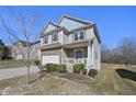 Attractive home showcasing a well-maintained lawn, neutral siding, and a cozy front porch at 1566 Wilson Manor Cir, Lawrenceville, GA 30045