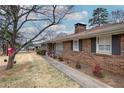 Side view of a brick home with black shutters and a manicured landscape at 224 E Felton Rd, Cartersville, GA 30121