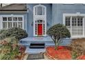 Charming front entrance with a vibrant red door and manicured bushes at 2382 Merrymount Dr, Suwanee, GA 30024