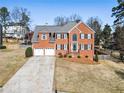 Beautiful two-story red brick home featuring a two-car garage and mature trees at 3176 Crestmont Nw Way, Kennesaw, GA 30152