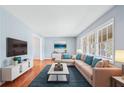 Bright living room features hardwood floors, a large window, and a comfortable sectional sofa at 2126 Chevy Chase Ln, Decatur, GA 30032