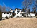 Beautiful white brick home with modern design elements, a well-maintained lawn, and pathway to the front door at 4524 Mystic Dr, Sandy Springs, GA 30327