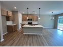Open-concept kitchen boasts an island, wood floors, and abundant natural light at 156 Easton Park Blvd, Dallas, GA 30157