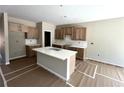 Bright kitchen featuring light wood cabinets, a marble countertop island, and stainless steel appliances at 156 Easton Park Blvd, Dallas, GA 30157