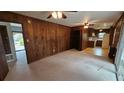 A spacious living room boasts wood paneling, a ceiling fan, and access to the kitchen and front entryway at 4112 Bontura Ct, Stone Mountain, GA 30083