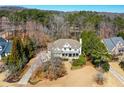 Expansive aerial view of a home with manicured lawn and driveway surrounded by lush trees and landscaping at 3150 Shumard Way, Marietta, GA 30064