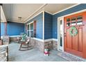 Charming porch with a wood door, stone pillars and rocking chairs at 316 Cranmore Pl, Villa Rica, GA 30180