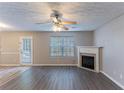 Open-concept living room with wood-look floors and a corner fireplace at 527 Carlton Pointe Dr, Palmetto, GA 30268