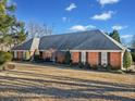 Spacious front yard with a red brick home, mature trees, and manicured shrubs creating a serene setting at 290 Connemara Ne Dr, Marietta, GA 30067