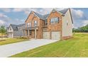 Traditional brick and siding home with two-car garage, manicured lawn, and dark shutters at 300 Bianca Way, Mcdonough, GA 30253