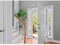 Bright entryway featuring wood floors, staircase, and view to the front porch at 308 Helena Pl, Mcdonough, GA 30252