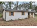 View of the side of the home with painted brick and dark trim and wooden shutters at 1700 Shirley Sw St, Atlanta, GA 30310