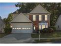 Charming two-story home with a two car garage and a brick facade at dusk at 3331 Freedom Nw Lndg, Kennesaw, GA 30144