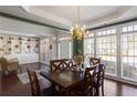 Bright dining area showcasing elegant chandelier, large windows, hardwood floors and stylish built-in bookcase at 3405 Belridge Se Dr, Smyrna, GA 30080