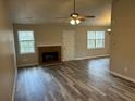 Open-concept living room with brick fireplace, ceiling fan and wood flooring at 4227 Sheppard Xing Way, Stone Mountain, GA 30083