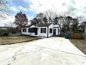 Charming home featuring a white exterior with black trim, a concrete driveway, and a well-maintained front yard at 1298 Belmont Se Ave, Smyrna, GA 30080