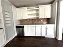 Spacious kitchen features stainless steel dishwasher, floating shelves, and white cabinets at 1298 Belmont Se Ave, Smyrna, GA 30080