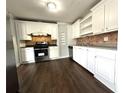 Bright kitchen features stainless steel appliances, dark wood floors, granite counters, and white cabinets at 1298 Belmont Se Ave, Smyrna, GA 30080