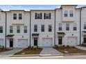 Charming townhome exteriors featuring white siding, individual garages, and professionally landscaped yards at 3151 Washburn Sw St, Atlanta, GA 30354
