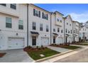 Beautiful townhome exteriors featuring white siding, black trim, private garages, and manicured landscaping at 3151 Washburn Sw St, Atlanta, GA 30354
