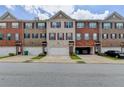 A street view of townhomes displaying diverse brick and siding exteriors, each with a garage at 2137 Post Grove Rd, Snellville, GA 30078
