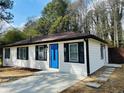 Renovated single-story home boasts a blue front door, fresh paint, and modern black window trim at 2745 Marco Nw Dr, Atlanta, GA 30318