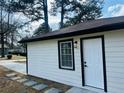 Side view showing the fresh paint, modern black trim, and stone pathway at 2745 Marco Nw Dr, Atlanta, GA 30318