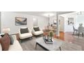 Bright living room open to dining area with modern decor and hardwood floors throughout at 30 Dunwoody Springs Dr, Atlanta, GA 30328