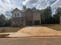 Two-story home boasts a brick facade, attached two-car garage and manicured lawn at 1590 Sungrown Way, Mcdonough, GA 30253