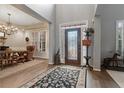 Inviting foyer with hardwood floors, rug, stained glass door, and dining room view at 6715 Brookline Ct, Cumming, GA 30040