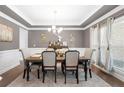 Formal dining room with large window, tray ceiling, and neutral color palette at 6117 Summerstone Ln, Douglasville, GA 30135