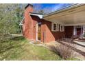 Brick home with a covered carport featuring an exterior side door and a small chimney at 6582 Malvin Dr, Mableton, GA 30168