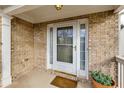 Inviting front entrance with brick surround, decorative columns, and a charming welcome mat and potted plant at 6690 Cold Stream Dr, Cumming, GA 30040