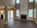 Spacious living room boasts a fireplace, floor-to-ceiling windows, and an open layout connected to the kitchen at 875 Under Ct, Sugar Hill, GA 30518