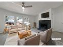 Bright living room featuring a fireplace, large windows, and neutral-colored furniture at 8072 Crystal Ln, Douglasville, GA 30134