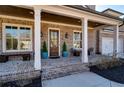Inviting front porch with brick flooring, classic columns, and stylish seating, perfect for relaxing outdoors at 14 Long Island Pl., Atlanta, GA 30328