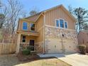 Inviting two-story home with tan siding, stone accents, and a two-car garage with green lawn at 2796 Lakeview Walk, Decatur, GA 30035