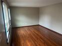 An empty bedroom featuring hardwood floors and a window with closed blinds for privacy at 5790 Northspring Dr, Ellenwood, GA 30294
