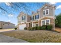 Angle view of a two-story home with stone accents, showing driveway and landscaped lawn at 1183 Lanier Springs Dr, Buford, GA 30518