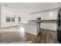 Modern kitchen featuring white cabinetry, an island with a granite countertop, and stainless-steel appliances at 1183 Lanier Springs Dr, Buford, GA 30518