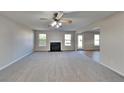 Spacious living room with a fireplace, ceiling fan, and neutral carpeting at 4928 Bryant Dr, Snellville, GA 30039