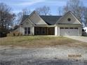Charming single-story home boasts a two-car garage and inviting front facade with brick detailing at 561 Old Loganville Rd, Loganville, GA 30052